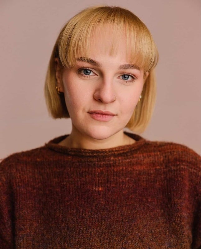 Studio portrait of a young person with short blonde hair