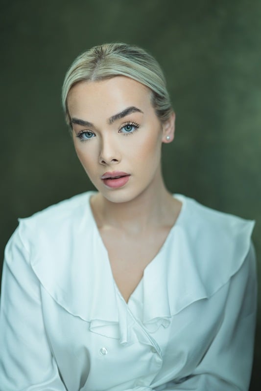 Studio portrait of a young woman in a white blouse