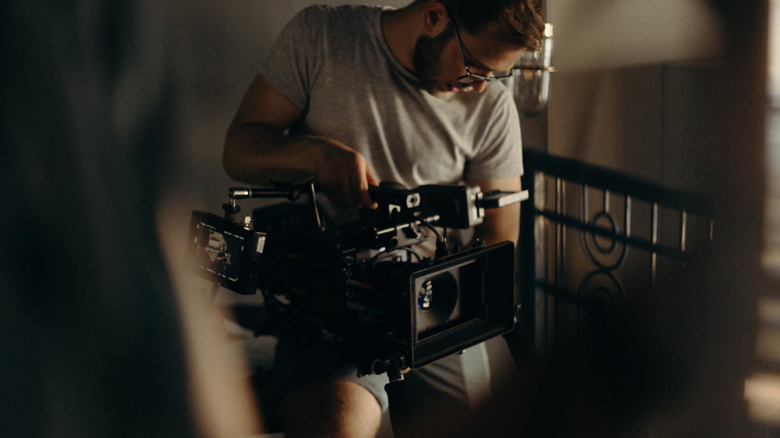 A filmmaker adjusting a professional cinema camera